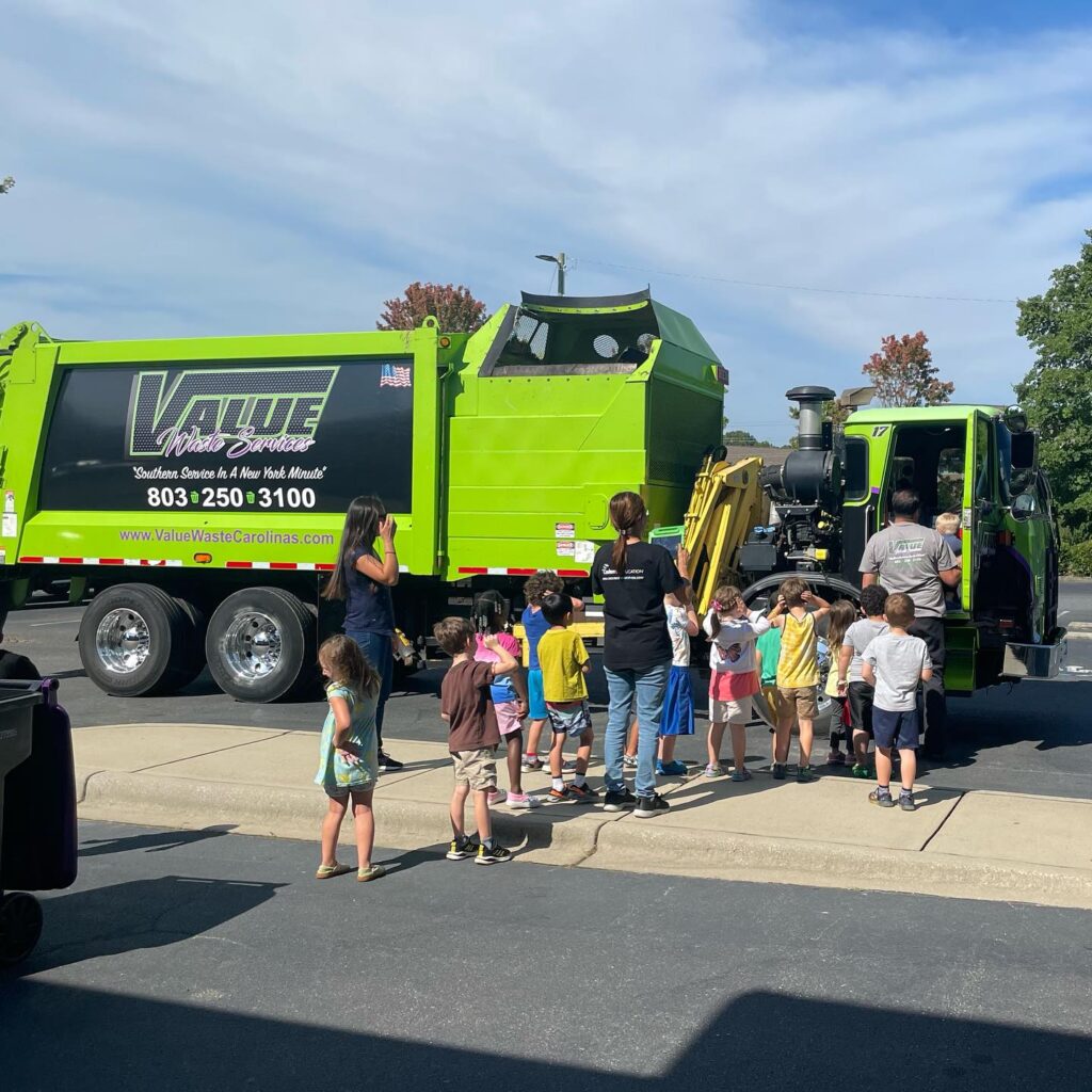 A Value Waste garbage truck with the American flag and the company logo.