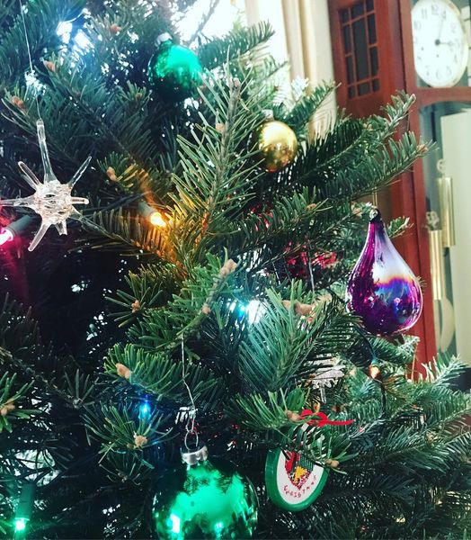 A close-up of a Christmas tree decorated with colorful ornaments and lights.