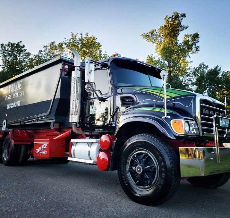 A black roll-off truck with the Value Waste logo, parked on a street.